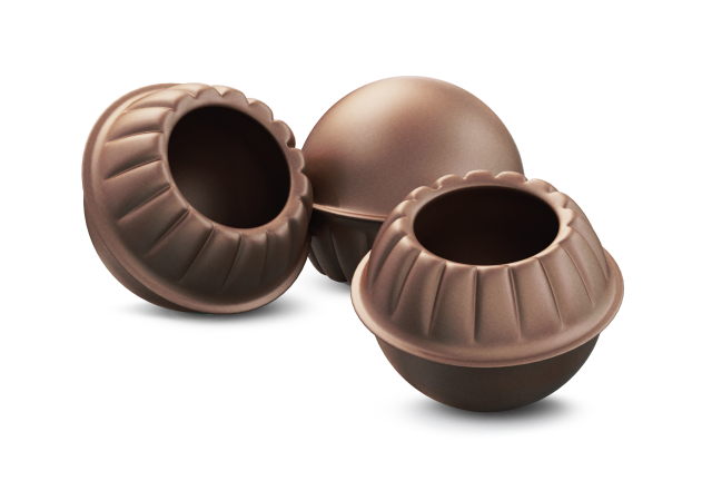 Três cascas ocas de chocolate em formato de esfera com bordas onduladas, uma bola inteira atrás de duas taças abertas...