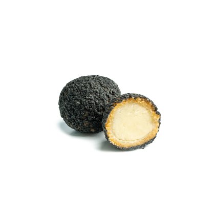 Duas bolinhas de queijo cobertas com trufa negra em fundo branco, uma inteira e outra cortada mostrando o interior cr...